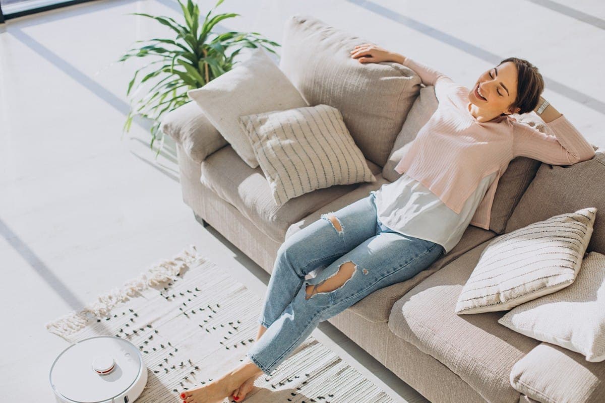 Personne détendue sur un canapé dans le salon lumineux d'un logement moderne et confortable