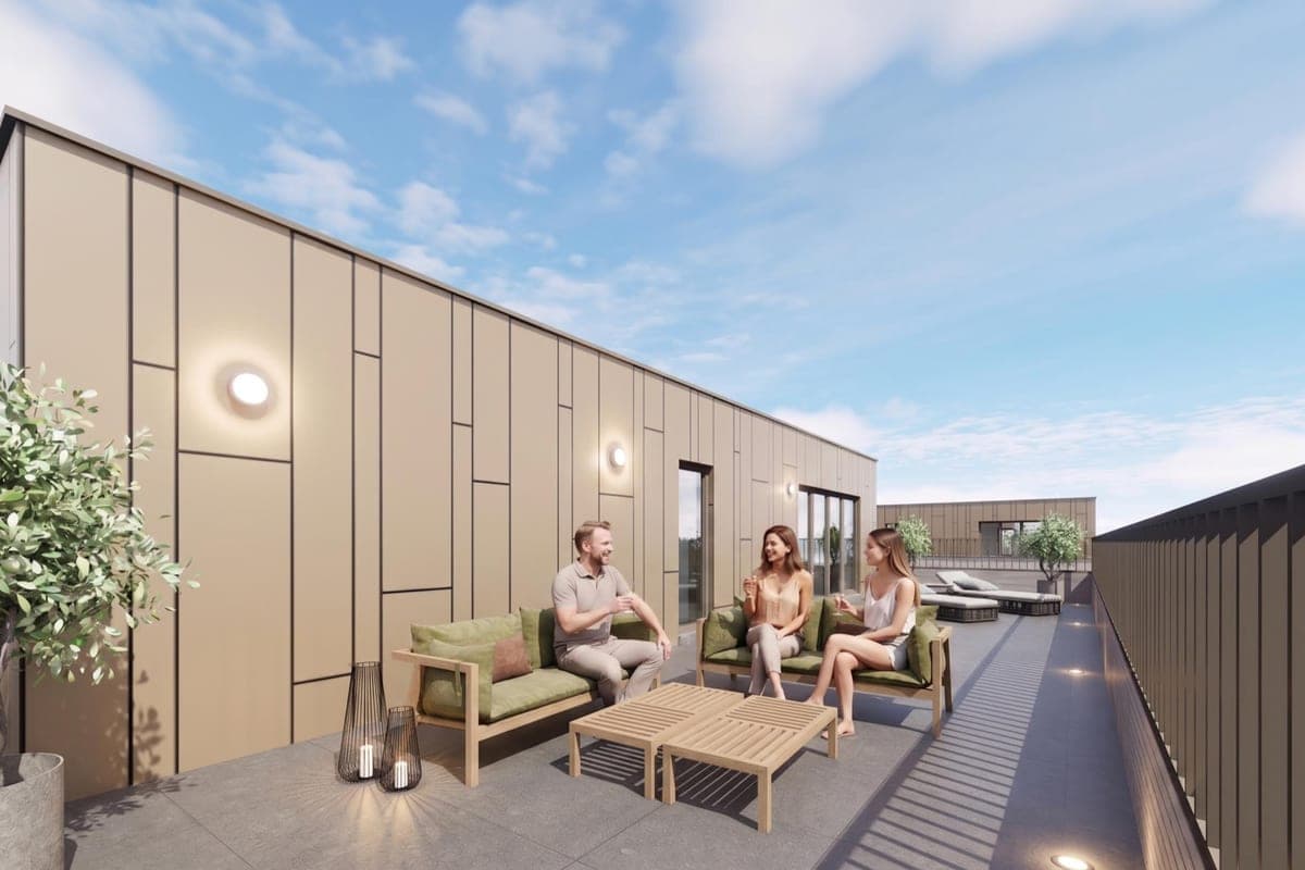 Trois personnes discutant sur une grande terrasse aménagée d'une résidence neuve, sous un ciel dégagé